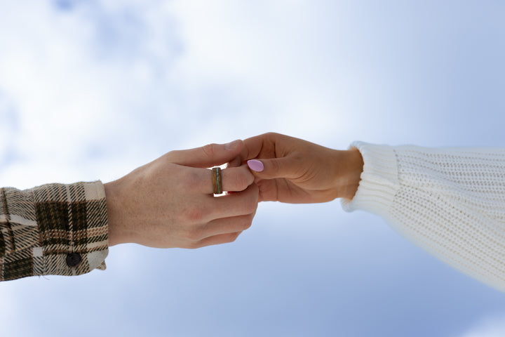 Holding hands wearing a wood wedding ring
