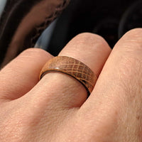 whiskey barrel ring with carbon fiber sleeve worn on a hand