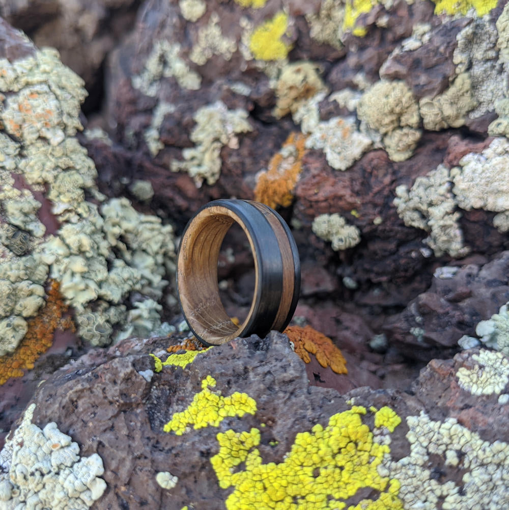 Men's Whiskey Barrel Band with Carbon Fiber On Mossy Rocks
