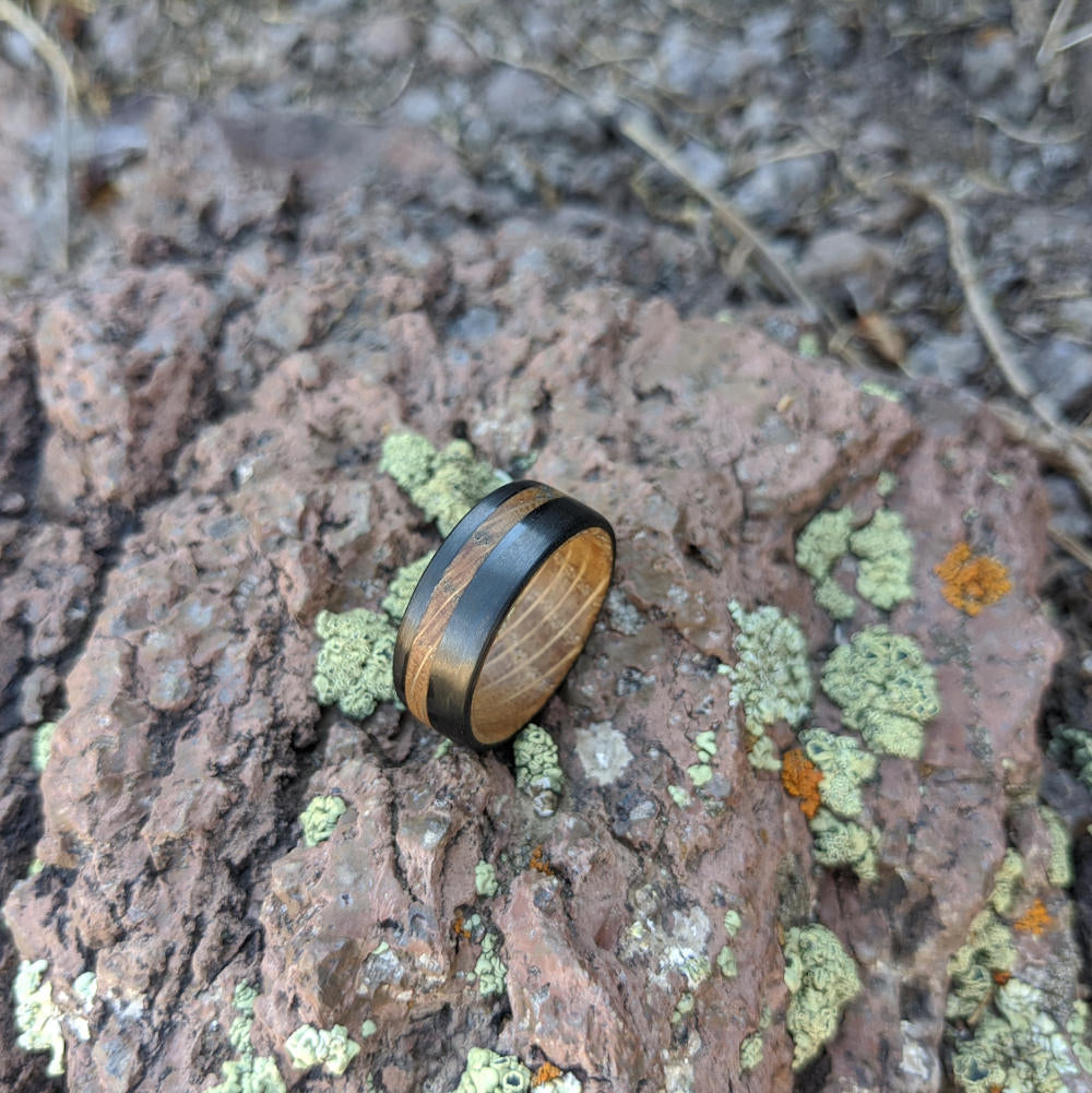 Men's Whiskey Barrel Band with Carbon Fiber On A Mossy Stone