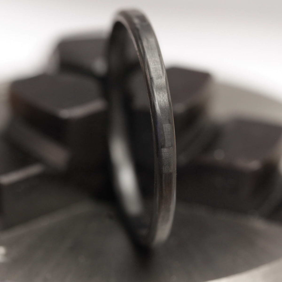 black stackable ring made from carbon fiber pattern close up