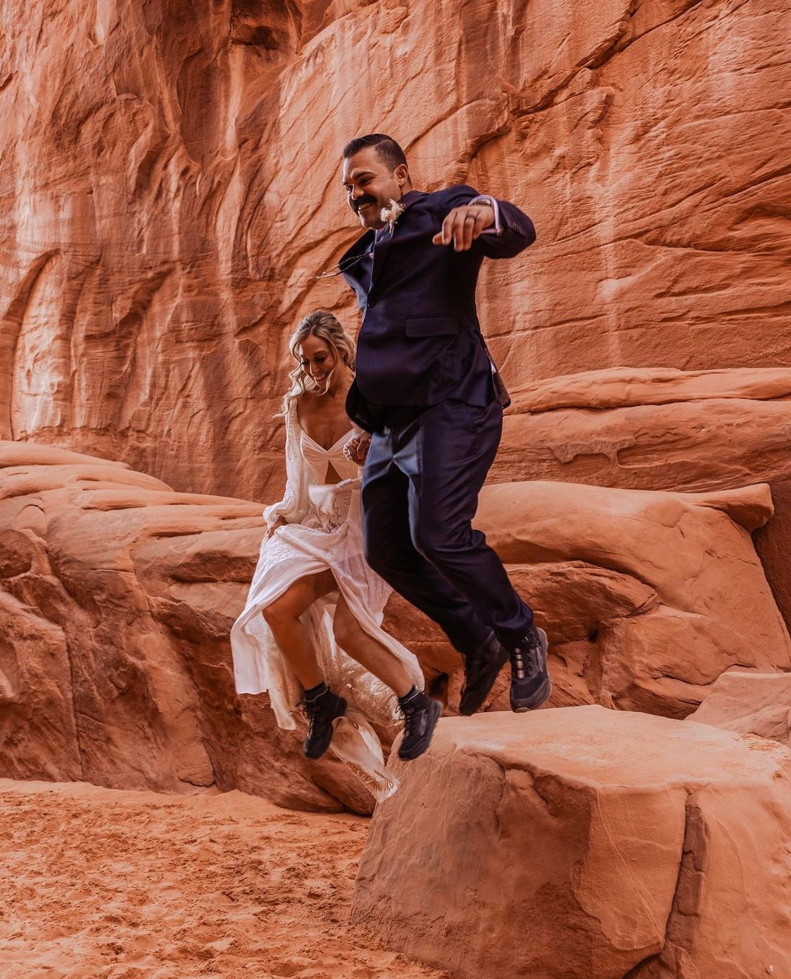 Couple jumping in red rock