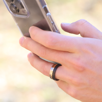 titanium ring with gold and carbon fiber inlays on hand