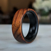 cocobolo ring with carbon fiber sleeve on a table