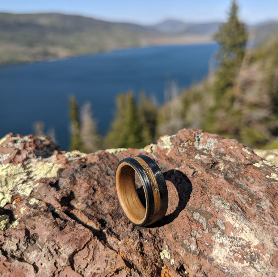 Men's Whiskey Barrel Band with Carbon Fiber On A Rock Overlooking A Lake