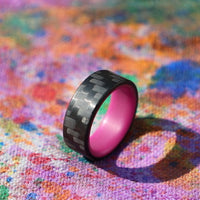 Purple Glow In The Dark Ring with Carbon Fiber on a colorful canvas