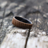 whiskey barrel ring with carbon fiber sleeve on a tree trunk