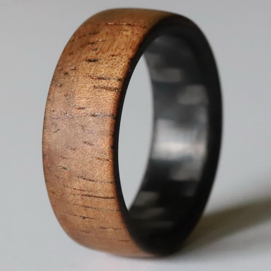 koa wood ring with carbon fiber sleeve wood close up