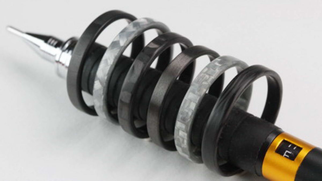 gray stackable ring made from glass fiber featured with other stackable rings on a pen