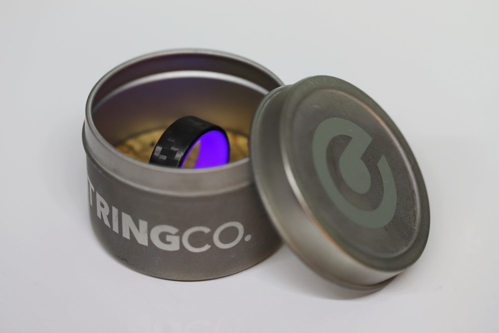 Purple Glow In The Dark Ring with Carbon Fiber glowing in its container