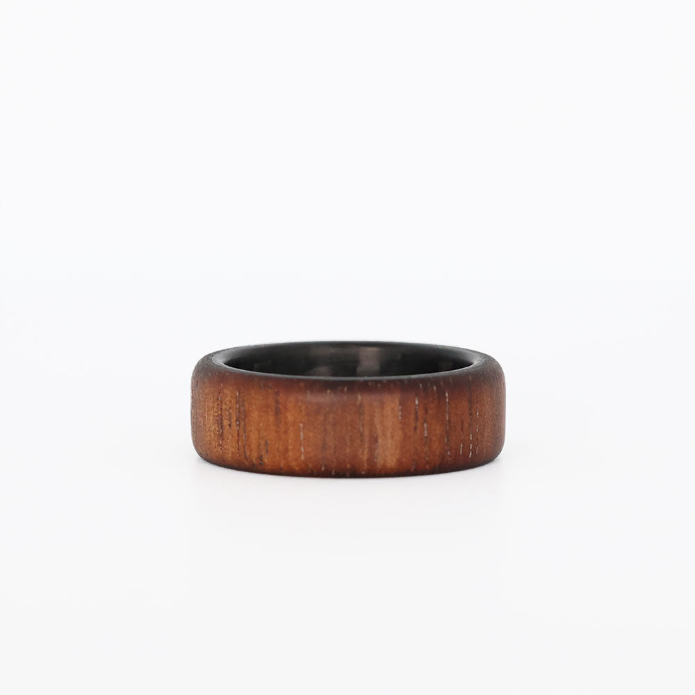 koa wood ring with carbon fiber sleeve laying flat