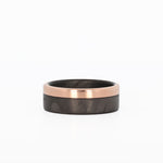 carbon fiber wedding band with rose gold rail laying flat