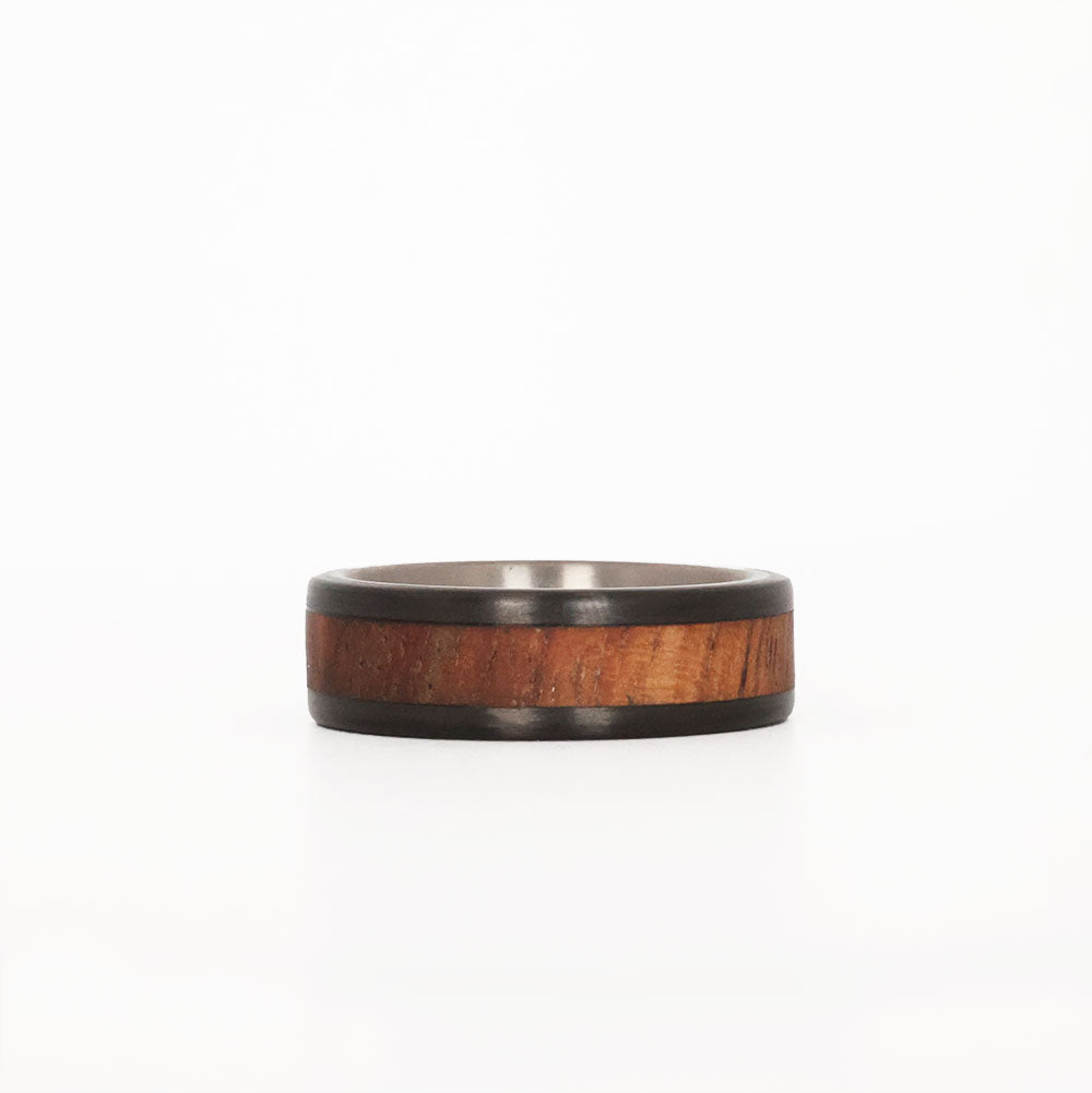 men's koa wood ring with carbon fiber rails and titanium sleeve laying down