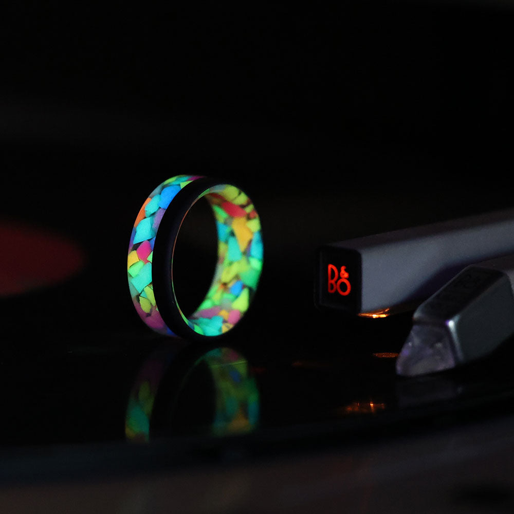 pride glow in the dark ring with black carbon fiber rail glowing on vinyl record player