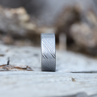 Damascus Ring Front View On A Rock